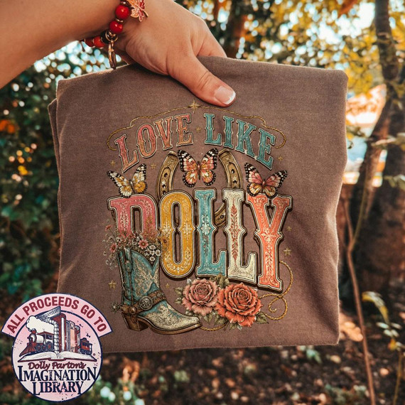 Love Like Dolly DTF Transfer, retro western country music design on brown fabric showcasing butterflies, roses, a cowboy boot, and colorful vintage-style lettering.