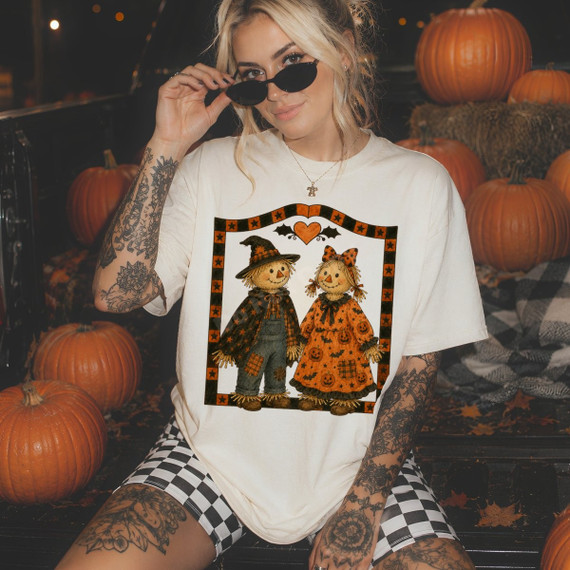 Country scarecrow couple DTF transfer with pumpkin-print dress, patched overalls, and star-bordered frame with a heart accent