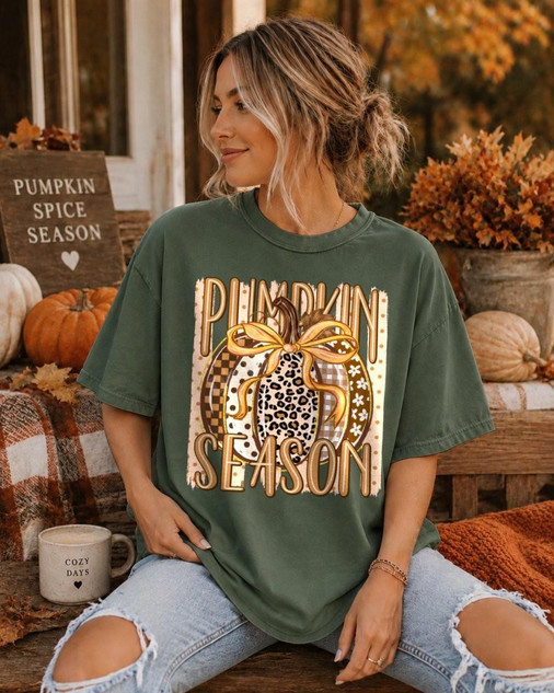 Pumpkin Season DTF Transfer, leopard and plaid patchwork pumpkin design on a green T-shirt worn by a woman in autumn setting with pumpkins and fall decor.