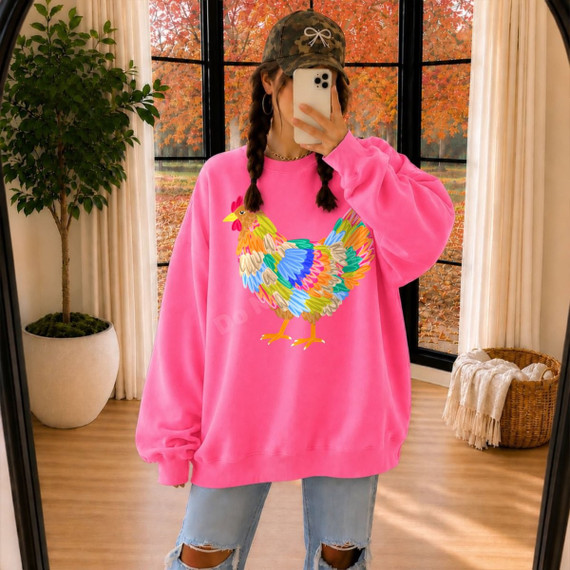 Colorful rainbow chicken DTF transfer with multicolor feather artwork on a pink sweatshirt