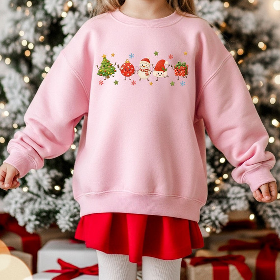 Cute Christmas cartoon DTF transfer with smiling tree, ornament, snowman, Santa hat character, and gift box on a pink youth sweatshirt