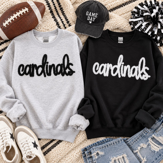 Black and white Cardinals fluffy script heat press patches displayed on light gray and black sweatshirts for school spirit apparel.