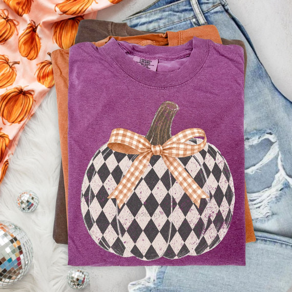Checkered black and cream pumpkin DTF transfer with distressed stem and orange gingham bow on a purple shirt