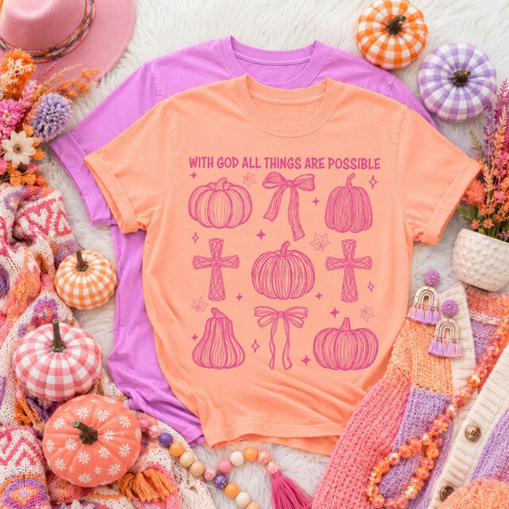 With God All Things Are Possible DTF transfer with hand-drawn pumpkins, crosses, and bows in pink line art on an orange shirt
