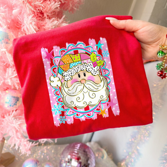 Colorful patchwork Santa face DTF transfer with polka dot beard, holly, stars, and snowflakes on a pink striped background