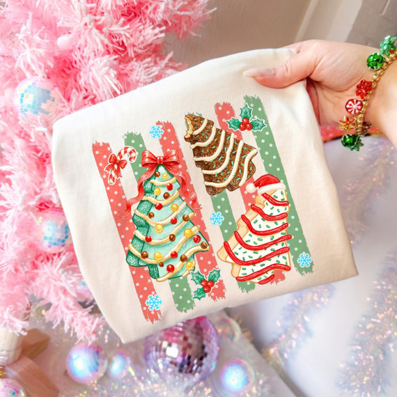 Christmas tree cake DTF transfer with three illustrated frosted tree-shaped cakes over red and green polka dot stripes with holly and snowflakes