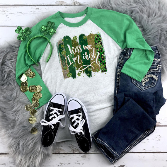 Kiss me I'm Irish patterned brush stroke sublimation transfer, green and gold graphic design on a casual sweatshirt for St. Patrick's Day.