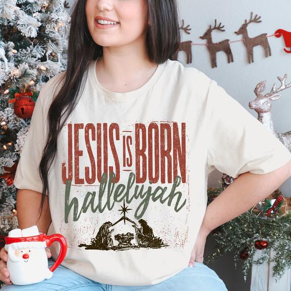 Jesus is Born Hallelujah Christmas DTF transfer with distressed red lettering, sage green script, and nativity scene silhouette on a natural colored shirt