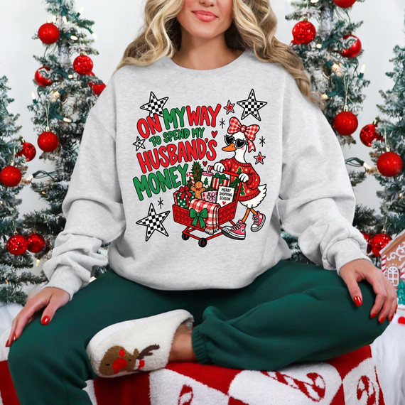 On My Way To Spend My Husband's Money Christmas DTF transfer with sassy duck pushing a shopping cart full of gifts, checkered stars, and plaid bow
