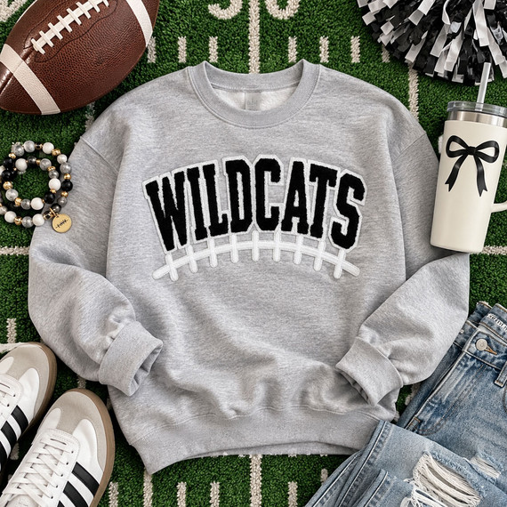 Black and white Wildcats football chenille patch with varsity lettering, white puff embroidered football laces and thin sequin outline for game day apparel