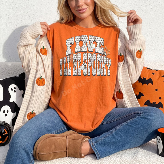 Fine I'll Be Spooky DTF transfer in bold arched skull-pattern lettering with spiderweb and ghost accents on an orange shirt