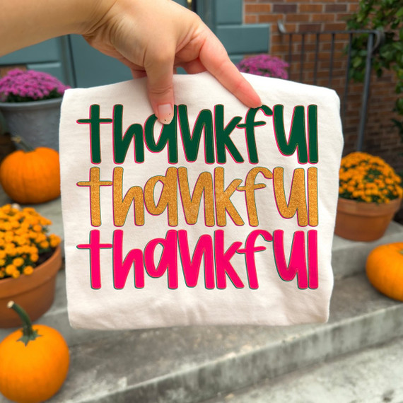 Thankful DTF transfer repeated three times in green, gold glitter-style, and pink retro lettering for fall shirts