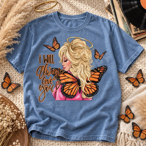 I Will Always Love You DTF transfer featuring an angelic blonde woman with a golden halo, pink outfit, and monarch butterfly wings surrounded by fluttering butterflies Shown on a Mystic Blue t-shirt.