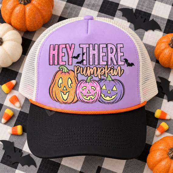 Hey There Pumpkin Halloween DTF transfer with star-patterned lettering, three pastel jack-o'-lanterns, and black bats Shown on a lavender front panel, black bill, cream mesh back, orange rope trucker hat.