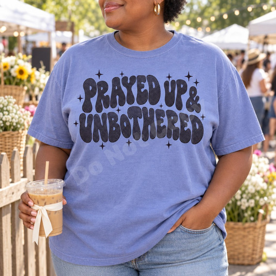 Prayed Up & Unbothered DTF transfer in black bubble-letter lettering with halftone texture and sparkle star accents Shown on a Periwinkle t-shirt.