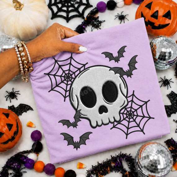 Halloween DTF transfer with embroidery-style skull, spiderwebs, and bats design on a purple shirt