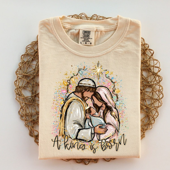 A King Is Born DTF transfer featuring a hand-painted nativity scene of Mary, Joseph, and baby Jesus with the Star of Bethlehem and string lights