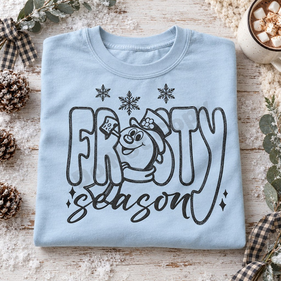 Frosty Season DTF transfer with cartoon snowman in top hat peeking through chunky bubble letters, snowflakes, and brush-script lettering Shown on a Ice Blue t-shirt.