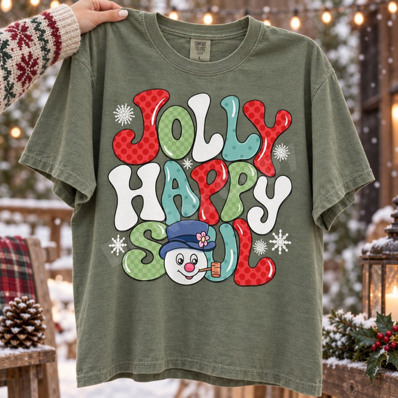 Jolly Happy Soul bubble-letter Christmas DTF transfer with snowflakes and a smiling snowman in a blue top hat holding a pipe Shown on a Moss t-shirt.