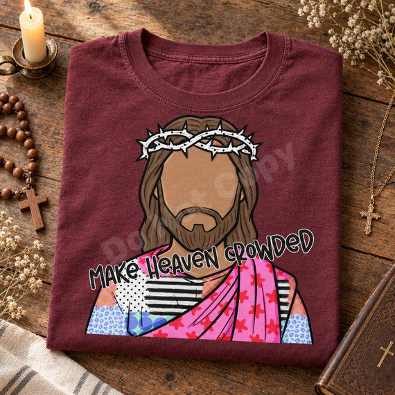 Make Heaven Crowded DTF Transfer | Faith-Based Jesus Design, colorful cartoon Jesus wearing a crown of thorns with “Make Heaven Crowded” lettering, displayed on a folded burgundy T-shirt.