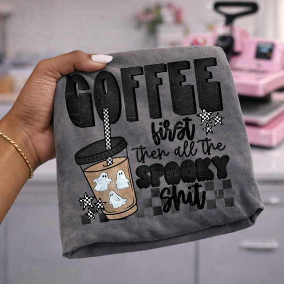 Coffee First Then All The Spooky Shit DTF Transfer | Funny Halloween Coffee Design, black Halloween design on a gray shirt featuring bold lettering, a ghost-filled iced coffee cup, checkerboard details, and stars.