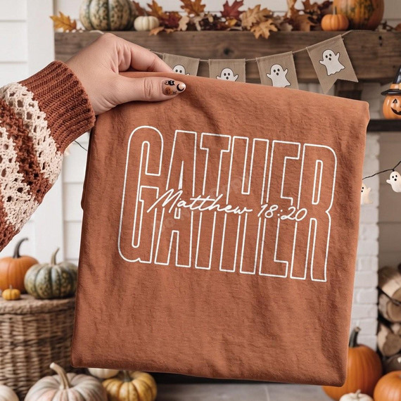 Gather Matthew 18:20 DTF Transfer | Retro Fall Faith Design, white outlined “Gather” lettering with Matthew 18:20 scripture displayed on a rust-colored shirt in a cozy autumn setting with pumpkins and fall leaves.