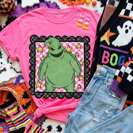 Spooky Sack Monster DTF Transfer | Pink Checkered Halloween Design, green stitched monster with a mischievous grin and yellow stars on a pink checkerboard framed in black, displayed on a bright pink shirt with Halloween accessories