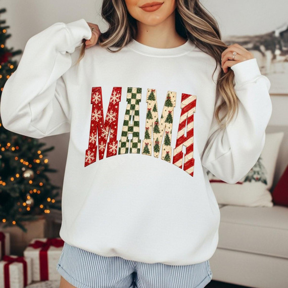 Christmas Mama DTF Transfer | Arched Holiday Letters Design, festive red, green, and cream patterned MAMA lettering displayed on a white sweatshirt in a cozy Christmas setting