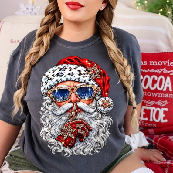 Hand-painted Santa Claus DTF transfer in jeweled sunglasses with snowy pine reflection, leopard print hat trim, and finger over lips in a shh pose