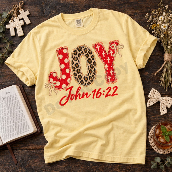 JOY faux-embroidered applique DTF transfer with red polka dot, leopard print, and cross-patterned letters, cream bows, and red script John 16:22 Bible verse Shown on a Butter t-shirt.
