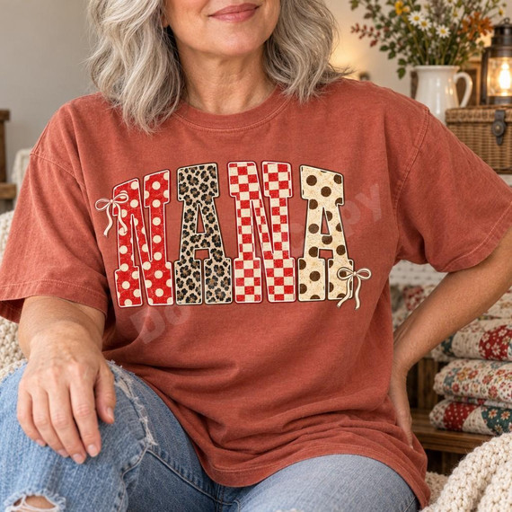 Nana Patchwork DTF Transfer | Polka Dot, Leopard & Checkerboard Word Art, close-up of a woman wearing a rust-colored T-shirt featuring bold “NANA” lettering in red polka dot, leopard print, red checkerboard, and cream polka dot patterns with bow accents.