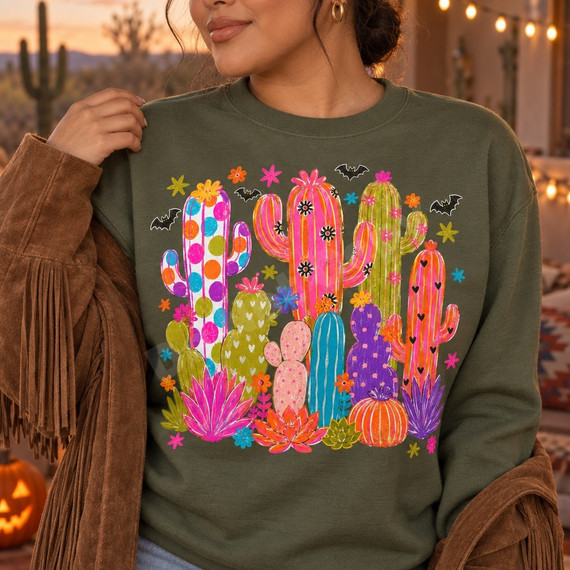 Whimsical folk-art cactus garden DTF transfer with polka dot, heart, and striped cacti, succulents, a striped pumpkin, bright flowers, stars, and black bats Shown on a Military Green crewneck sweatshirt.