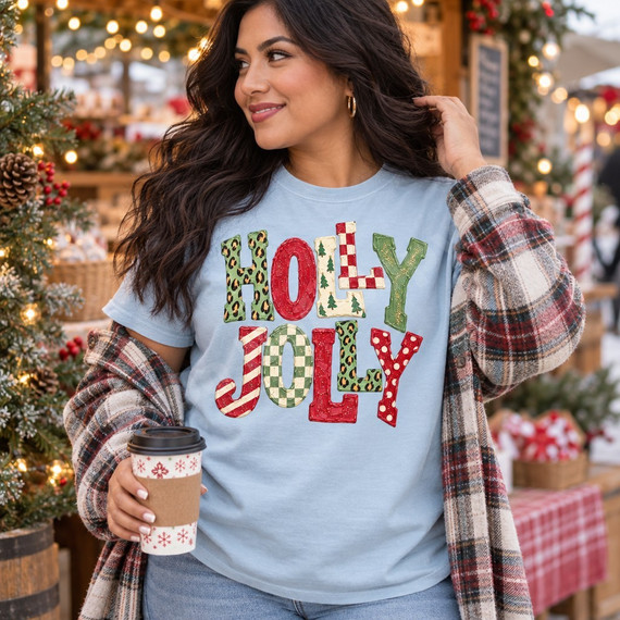 Holly Jolly Christmas DTF transfer in bold bubble letters with mixed leopard print, checkerboard, candy stripe, polka dot, and Christmas tree patterns Shown on a Ice Blue t-shirt.