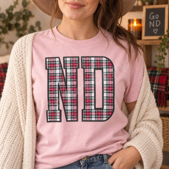 ND collegiate block letters DTF transfer filled with red, green, white, and black tartan plaid pattern and dark charcoal outline on a pink shirt Shown on a Blossom t-shirt.