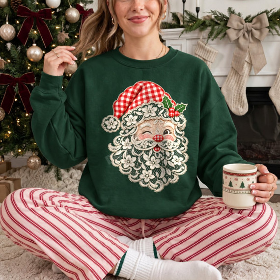 Winking Santa face DTF transfer with floral lace-inspired beard, buffalo plaid hat, and holly accent on a green sweatshirt