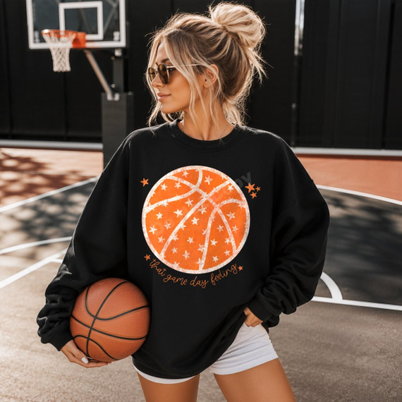 That Game Day Feeling basketball DTF transfer with distressed orange basketball graphic, star accents, and script lettering on a black sweatshirt