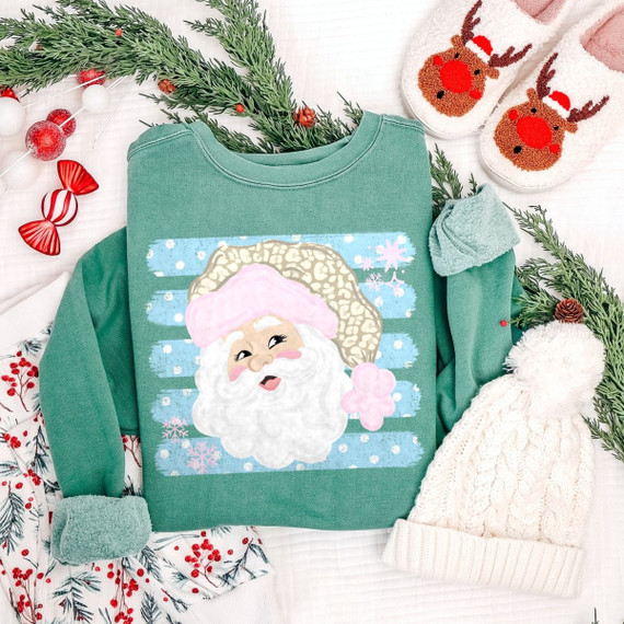 Pastel Santa face DTF transfer with leopard print hat and blue snowflake stripes on a green sweatshirt