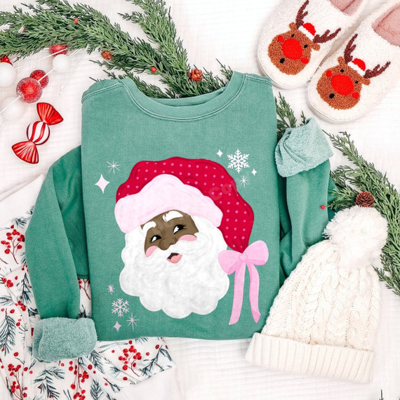 African American Santa face DTF transfer with pink polka-dot hat, pink bow, and sparkling snowflake accents on a green sweatshirt