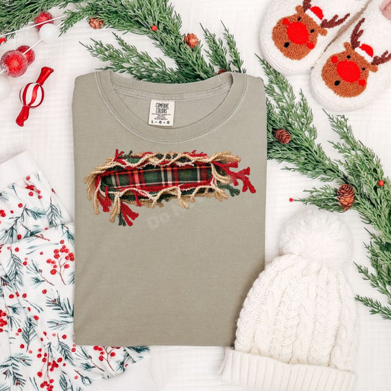 Faux-embroidered plaid garland patch DTF transfer with red, green, and gold fringe detail on a sage t-shirt