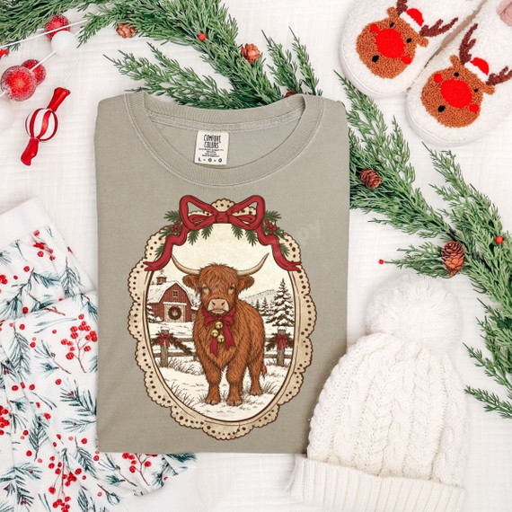 Christmas Highland cow DTF transfer in a vintage lace frame with red bow, jingle bells, and a snowy barn scene
