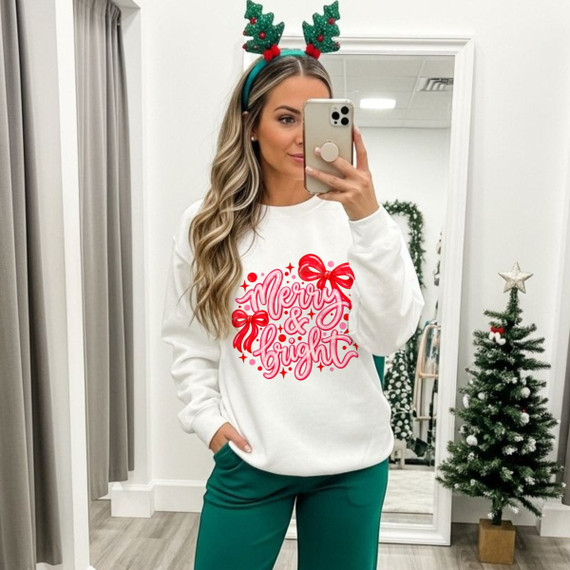Merry & Bright Christmas DTF transfer with pink and red script lettering and bow accents on a white sweatshirt