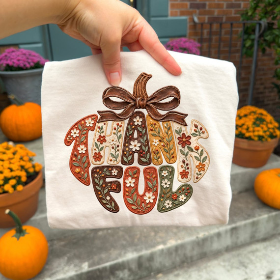 Thankful DTF transfer in pumpkin shape with floral embroidery-style lettering and a brown bow, in a fall color palette