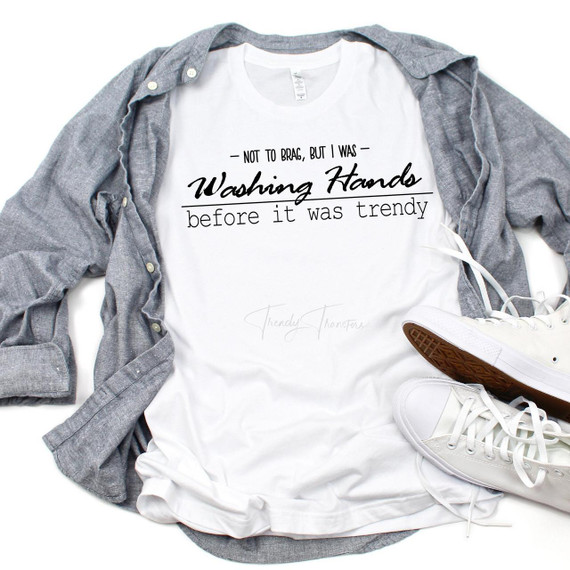 Not to brag but I was washing hands before it was trendy Sublimation Transfer T-shirt, white shirt with black text, casual sneakers, and a gray shirt laid out stylishly.