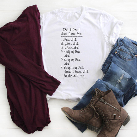 Shit I Don't Have Time For Sublimation Transfer T-shirt, white shirt with humorous text about not having time for sublimation transfer printing, styled with jeans, a maroon jacket, and brown boots.