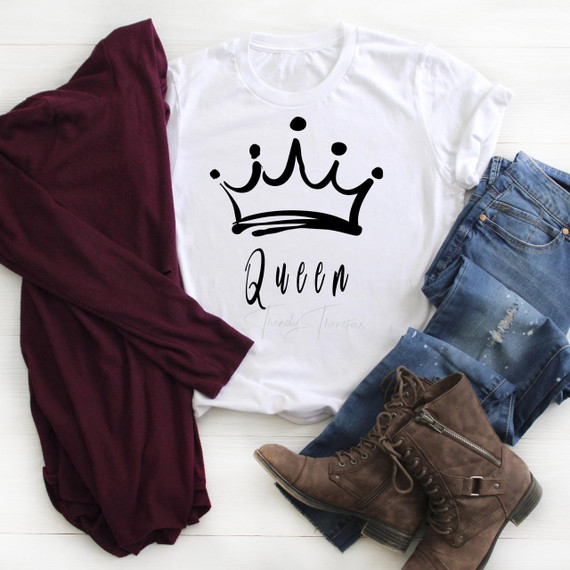 Queen Sublimation Transfer, graphic white T-shirt with a crown design and the word Queen on it, alongside denim jeans, a burgundy jacket, and brown boots, arranged on a white surface.