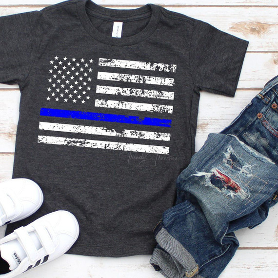 Thin Blue Line Flag YOUTH & INFANT - FINAL STOCK Screen Print Heat Transfer T-shirt, displaying a distressed American flag with a blue line, on a dark grey shirt, paired with ripped jeans and white sneakers.