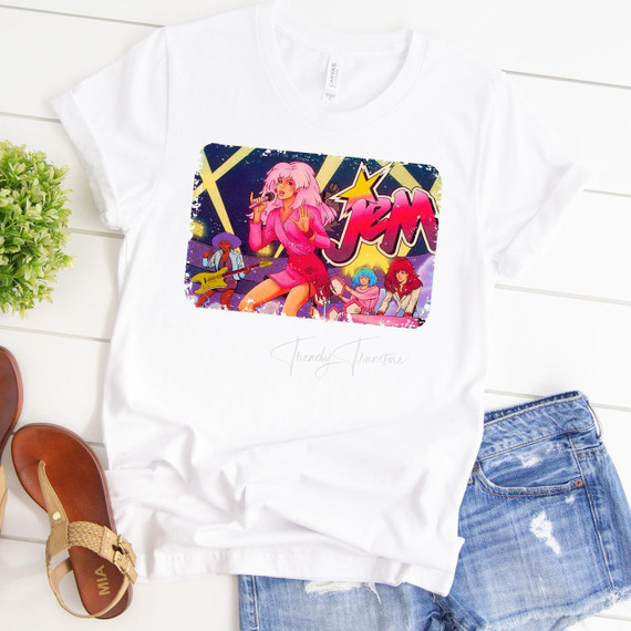 Jem and The Holograms Sublimation Transfer, colorful graphic T-shirt featuring Jem singing and playing guitar with band members in vibrant 80s style artwork.