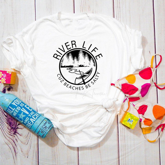 River Life cause beaches be salty sublimation transfer on a white t-shirt with a nature and river design in black, surrounded by colorful face masks and a water bottle.