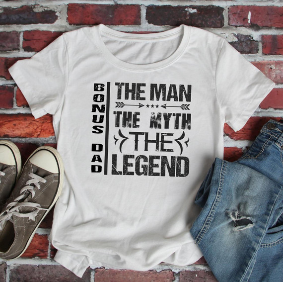 Bonus Dad The Man The Myth The Legend Sublimation Transfer, white t-shirt with bold black text design on a brick background.