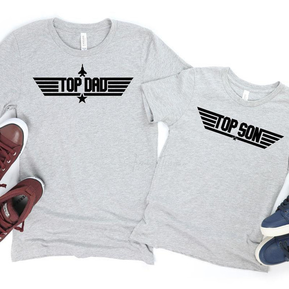 Top Son YOUTH Screen Print Heat Transfer, two gray youth T-shirts with black graphic print designs featuring that say 'Top Dad' and 'Top Son' in a bold font with wing and star accents.